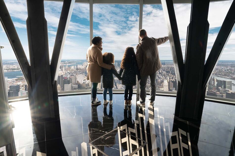 Family on the 102nd floor at the Empire State Building Observatory overlooking view.