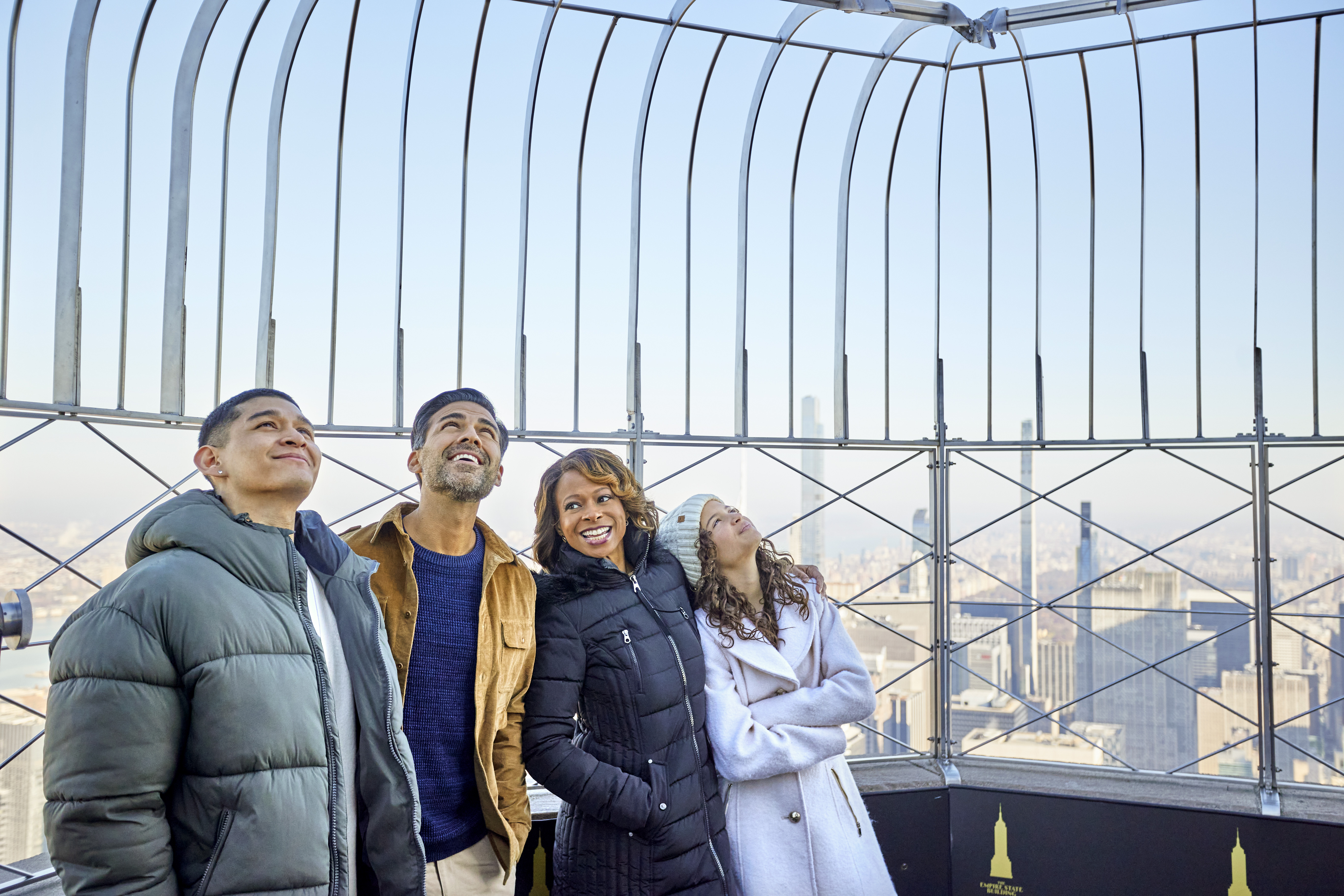 Family looking up from the Empire State Building's 86th floor outdoor observation deck.