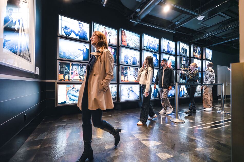 People observing the Worlds Most Famous Building 72-screen, 180-degree surround-sound theater exhibit on the 2nd floor of the Empire State Building Observatry experience.  