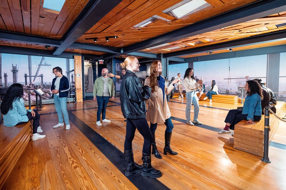 People observing the construction exhibit of the Empire State Building Observatry experience.  